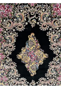 Close-up of the central medallion on a signed Persian Qum silk rug with gold scrollwork and rose floral details
