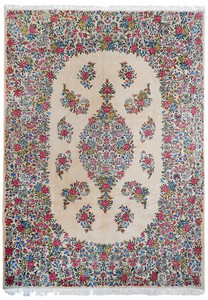 Straight-on image of a hand-knotted Persian Kerman rug featuring an ivory background, floral medallion, pastel pink flowers, and blue vine motifs