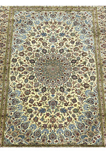 Midfield detail of a signed Persian Qum pure silk rug revealing dense floral motifs, flowing vine patterns, and crisp color transitions on an ivory background.