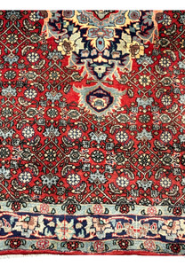 Lower border detail of a Persian Sarough rug showing navy and light blue framing, floral motifs, and precise hand-knotted craftsmanship