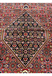Central medallion close-up of Persian Bijar rug showcasing intricate geometric patterning, dark ground, and refined color detailing