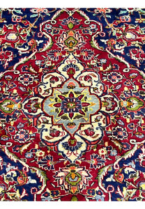Zoomed medallion detail of Persian Isfahan rug revealing fine knot density, precise floral drawing, and elegant color transitions