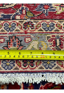 Backside view of Persian Isfahan rug with ruler demonstrating fine knot density, precise weaving, and consistent artisan craftsmanship