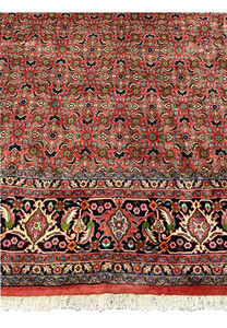 Lower border detail of Persian Bijar rug featuring floral vines, palmettes, and rich navy blue ground