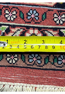 Close-up of Persian Bijar rug back with ruler measuring knots per inch, emphasizing high knot count