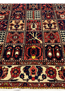 Lower border detail of a Persian Bakhtiar rug with ivory background and floral vine motifs
