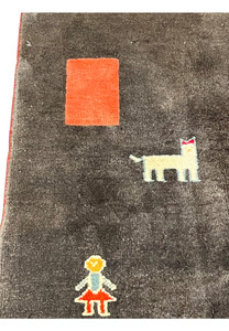 Pattern close-up featuring tribal bird and animal motifs on dark field with bright coral and navy accents and thick hand-knotted pile