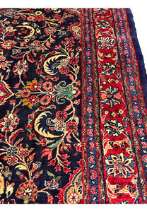 Angled perspective Persian Mahal rug highlighting pile height wool texture and rich navy and red color contrast
