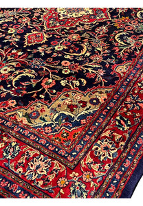 Close view of Persian Mahal rug inner border featuring red floral guard stripes, small blossoms, and navy outlines framing the deep blue field