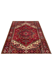 Top view of Persian Heriz area rug showing geometric medallion stepped motifs dense tribal field and classic border proportions