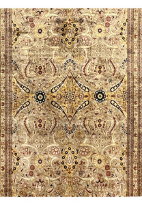 Midfield close view of Agra rug showing scrolling vines, rosettes, gold accents, and intricate beige tan floral detailing