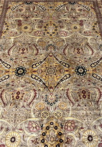 Closeup of central medallion area with golden motifs, rust florals, and fine hand knotted detail.