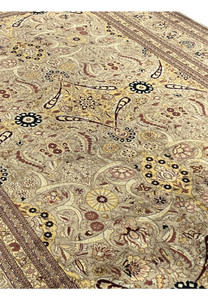 Angled view of distressed Agra rug field with scrolling vines, rosettes, gold medallions, beige tan palette, and softly faded antique finish