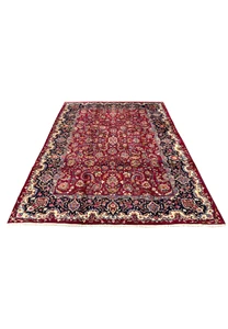 Laid down view of handmade Persian Mashad rug showing full proportions, rich red field, and elegant navy border framing