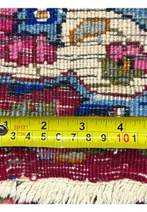 Backside closeup with ruler showing knot density and scale on Persian Mashad rug, confirming fine craftsmanship and precise hand weaving