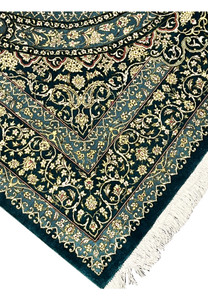Edge and fringe view of handmade silk Qum rug showing tight foundation, clean selvedge finish and ivory fringe against deep teal border