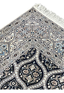 Upper edge detail of Persian Nain 6 LA rug with ivory fringe navy border and light blue floral guard stripes.