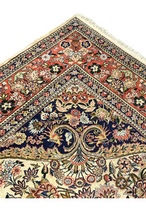 Folded edge of Persian Bijar rug displaying coral border navy guard bands and tightly woven pile structure