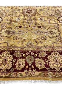 Lower border detail of 9x12 gold Agra rug showing burgundy floral border and ivory guard stripes.