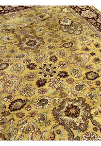 Field detail of antique style gold Indian Agra rug showing intricate floral pattern and vine scrolls.