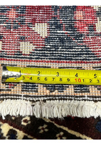 Backside of 7x10 Persian Bakhtiari rug with ruler showing knot density and cotton foundation