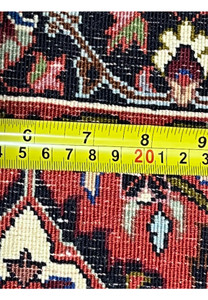 Back of authentic Persian Bijar rug measured with ruler, showing dense hand-knotted density