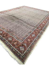 Angled view of authentic 10x13 Persian Moud rug with Herati field and floral border