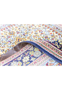 Hand-knotted Persian Qum kork rug folded showing 400 KPSI fine weave and ivory cotton fringe