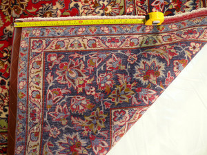 Unveiling the Back - Persian Isfahan Rug Density: Explore the craftsmanship from the other side, with a ruler highlighting the dense knots that make this 9'8 x 13'7 Persian Isfahan rug a true work of art.