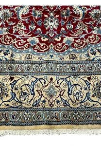 Lower border of Persian Nain rug featuring ivory floral band, navy outlines, and crisp guard border detailing