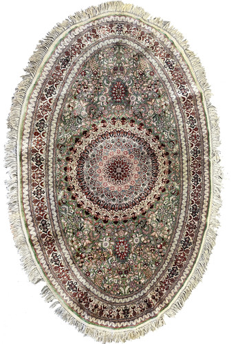 Full oval view of Persian Qum pure silk rug with dense 600 KPSI floral design, central medallion, and rich green, red, and ivory detailing.