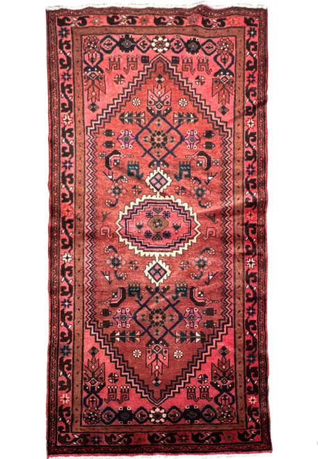 Full display of a handwoven Persian Baluch rug showcasing intricate tribal motifs and a rich color scheme