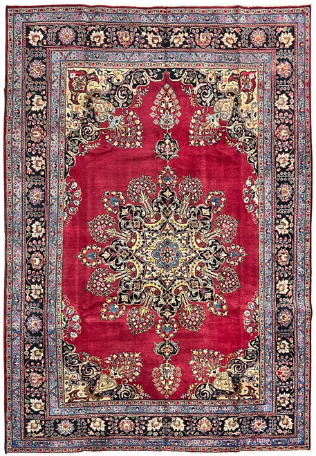 Full overhead view of Persian Kerman rug with crimson field, Lavar sunburst medallion, and navy main border