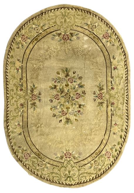 Antique oval hand-hooked floral rug with central rose bouquet and scrolled border, faded tan tones, sold as-is