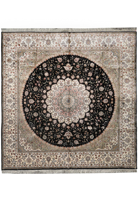Full square silk rug photographed flat, round black medallion centred within a wide ivory floral border