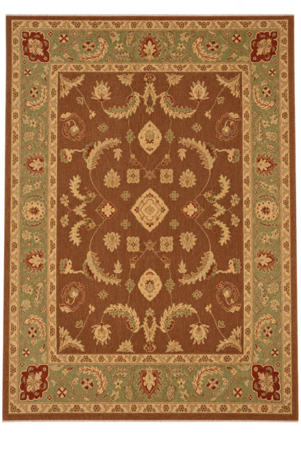 Full overhead view of the brown Oushak rug with green border against a tan studio backdrop