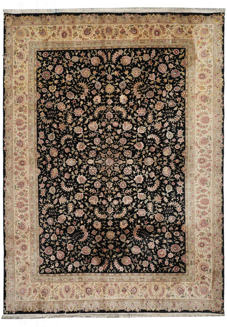 Full overhead view of the black-field Tabriz rug with wide ivory floral border and pale fringes