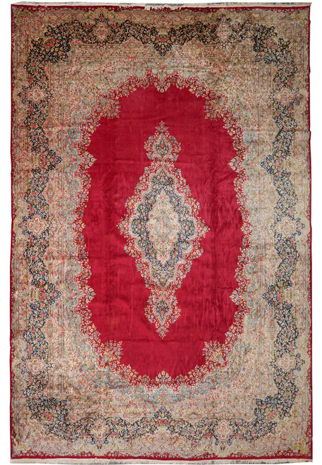 Full overhead view of red open field Persian Kerman rug with ivory floral border