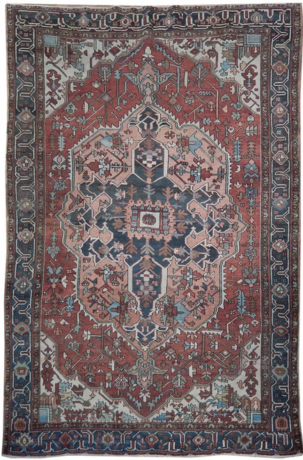 7'4" x 11'2" antique Persian Serapi rug shown flat, rust field with navy geometric medallion