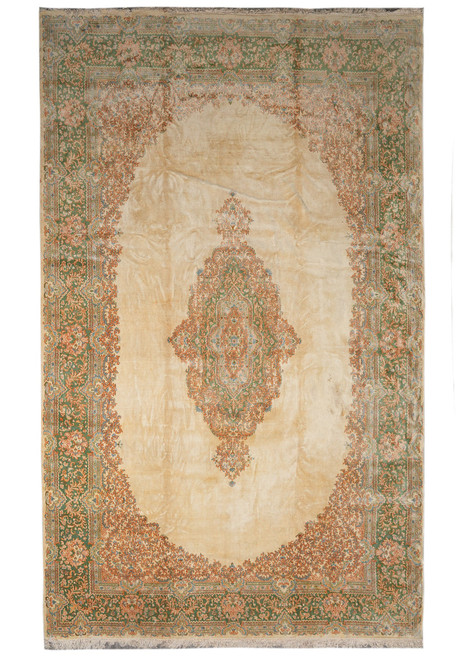 Full overhead view of oversize beige Persian Kerman rug with sage green floral border