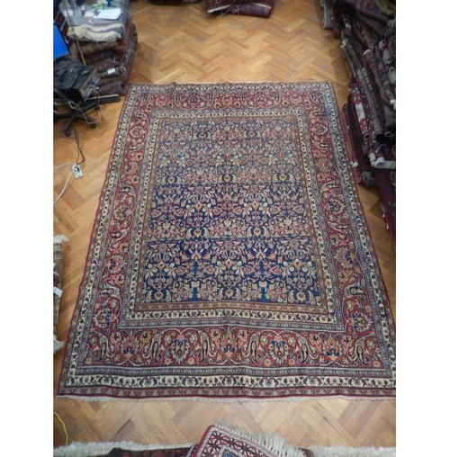 Overhead view of 9'6" x 13'1" Persian Khorasan rug with indigo floral field on parquet floor