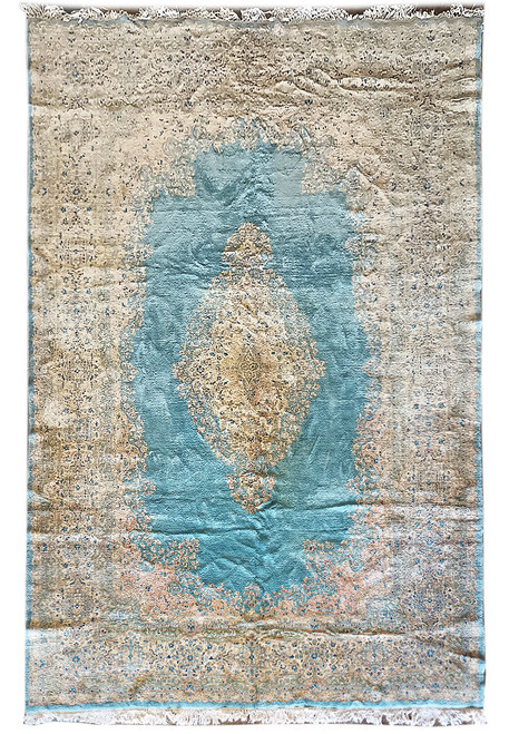 Full overhead view of light blue Persian Kerman rug with ivory floral border and central medallion