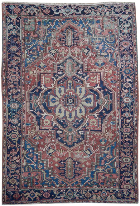 Antique Persian Heriz rug with rust red field, navy border and ivory geometric medallion centered