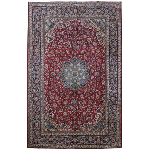 Overhead view of red Persian Isfahan rug with light blue star medallion and navy floral borders