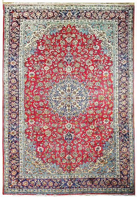 Bright studio image of red Persian Najafabad rug with navy floral border and ivory spandrels