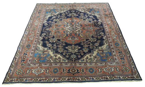 Navy blue Persian Kashan rug with salmon medallion and ivory corners photographed flat on white background