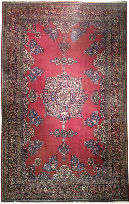 Full overhead view of raspberry red Persian Tabriz rug with star medallion and navy floral borders