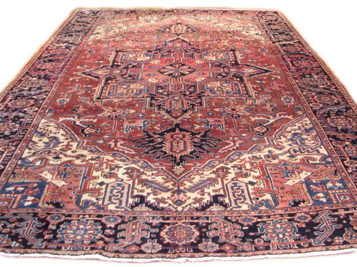 Full view of 8 x 11 Persian Heriz rug with rust red field and navy border