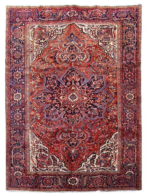 Full view 8'1" x 11'6" Persian Heriz rug with navy medallion on deep red field