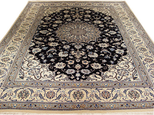 Full view of 6'7" x 10' Persian Nain rug with black field and ivory floral border